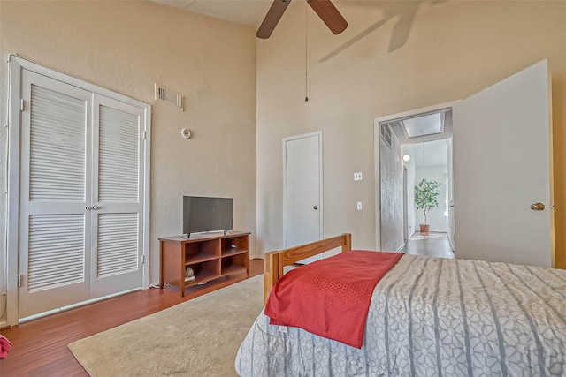 bedroom with ceiling fan, wood-type flooring, and a closet