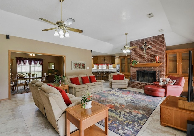 tiled living room with ceiling fan, brick wall, a brick fireplace, and vaulted ceiling