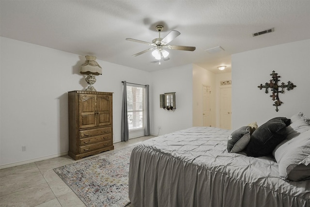 tiled bedroom featuring a textured ceiling and ceiling fan