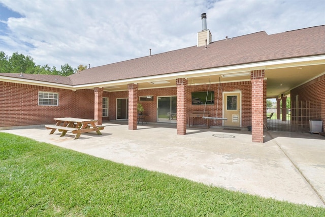 rear view of property with a yard and a patio area