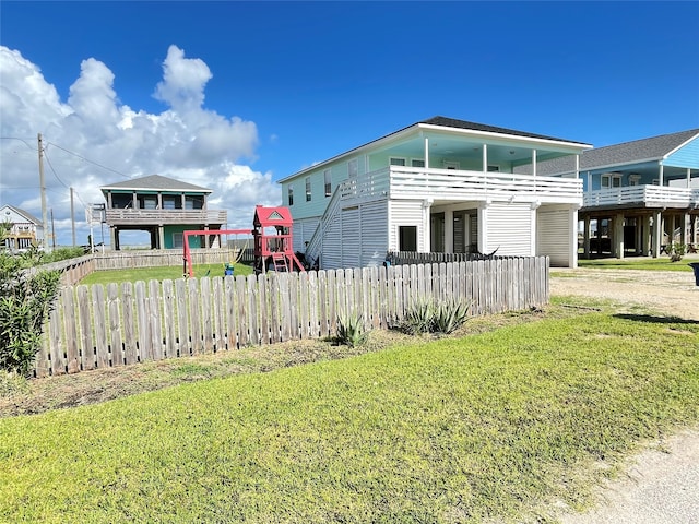 view of front of house with a balcony and a front lawn