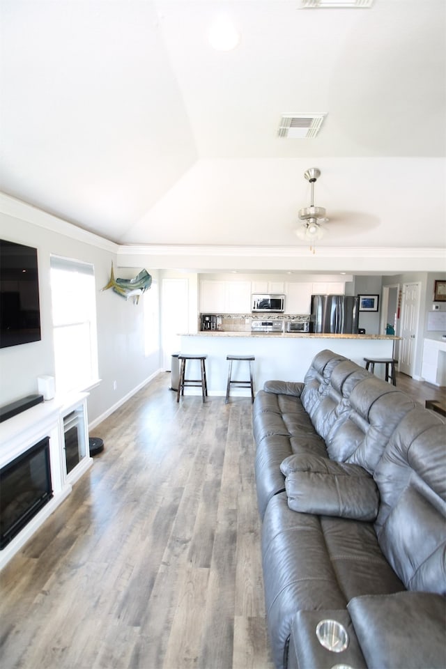 living room with vaulted ceiling, light hardwood / wood-style floors, and ceiling fan