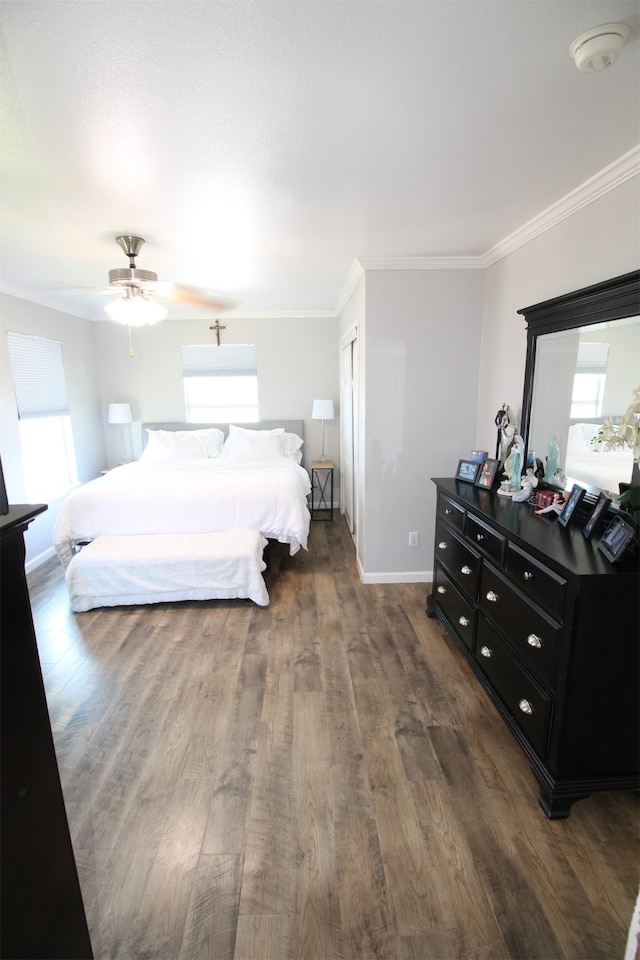 bedroom featuring crown molding, dark hardwood / wood-style floors, ceiling fan, and multiple windows