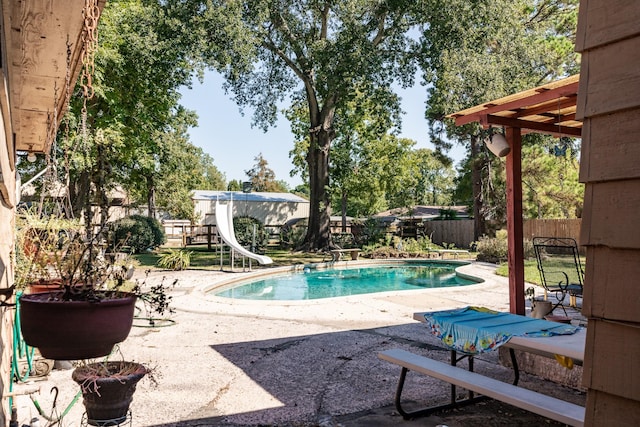 view of pool with a water slide and a patio area