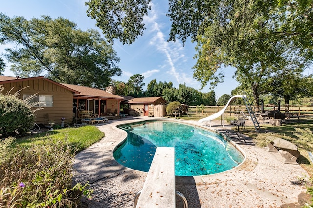 view of pool featuring a patio, a diving board, and a water slide