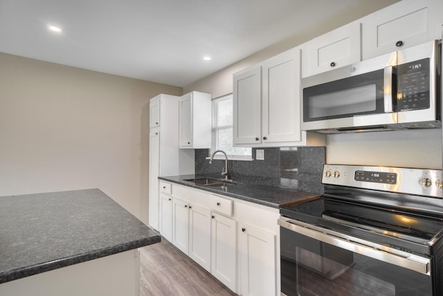 kitchen with light hardwood / wood-style floors, sink, appliances with stainless steel finishes, and white cabinetry