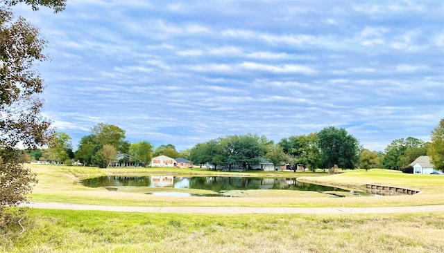 surrounding community featuring a water view and a yard