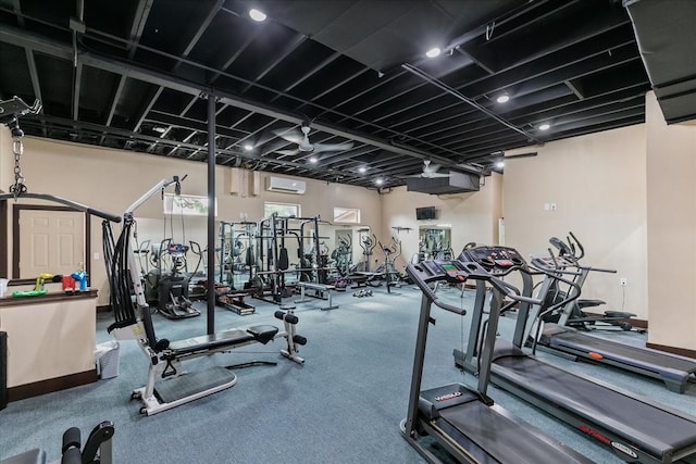 exercise room featuring carpet flooring and a wall unit AC