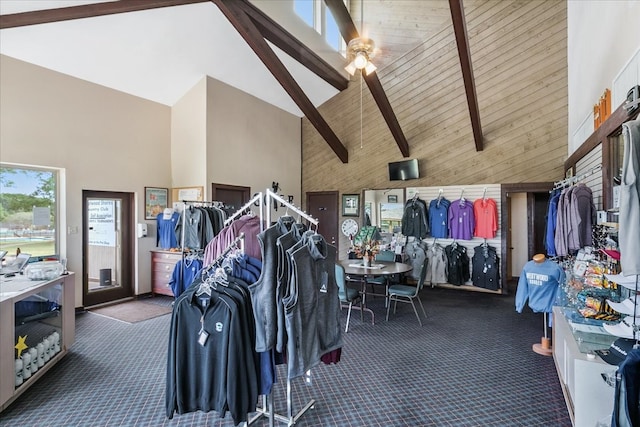 interior space with high vaulted ceiling, ceiling fan, dark colored carpet, and beamed ceiling