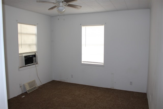 spare room featuring ceiling fan and dark carpet