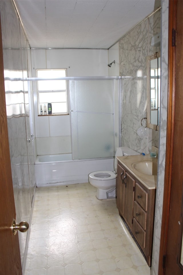 full bathroom with toilet, combined bath / shower with glass door, tile flooring, and vanity