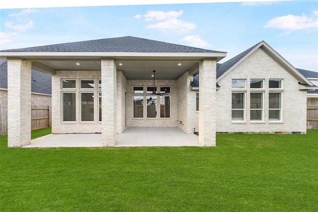 rear view of property with a lawn and a patio area