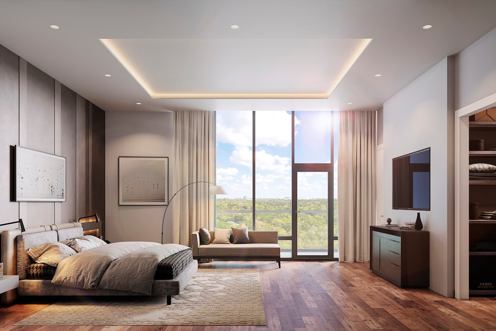 bedroom with floor to ceiling windows, a tray ceiling, and hardwood / wood-style flooring