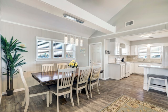 dining area featuring wood-type flooring, sink, a chandelier, and lofted ceiling