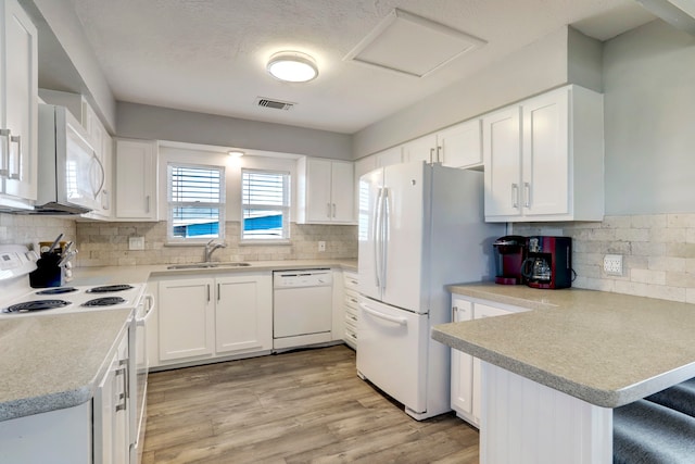 kitchen featuring sink, white appliances, light wood-type flooring, and backsplash