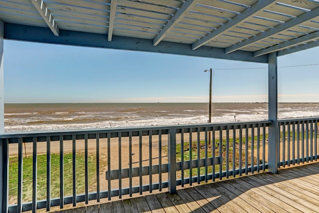 wooden deck with a water view and a view of the beach