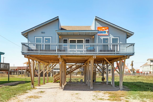 rear view of house with a wooden deck and a lawn