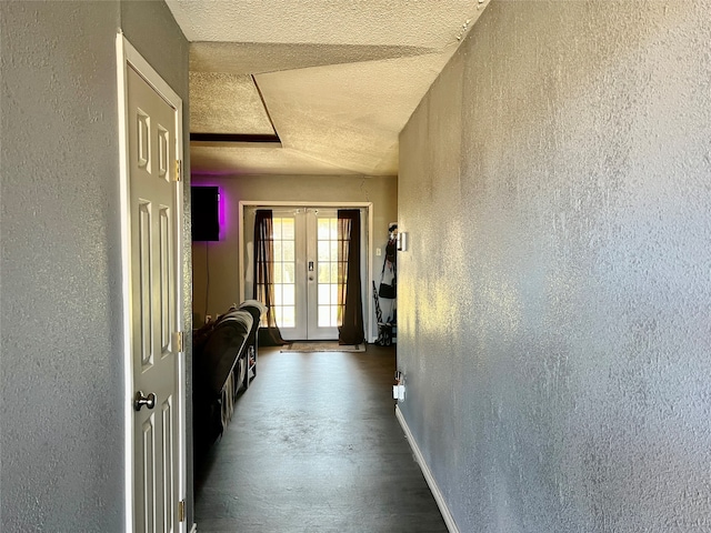 hallway featuring french doors and a textured ceiling