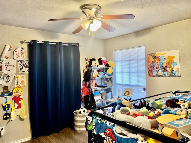 bedroom with dark wood-type flooring, a textured ceiling, and ceiling fan