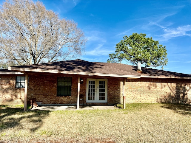 rear view of property with a lawn and french doors