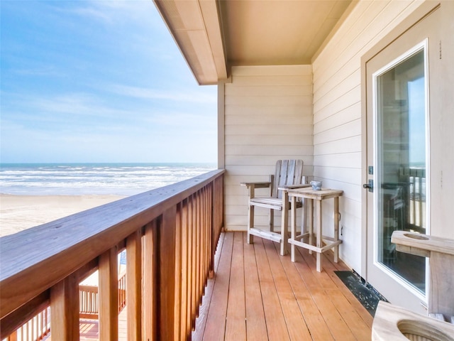 balcony with a water view and a view of the beach