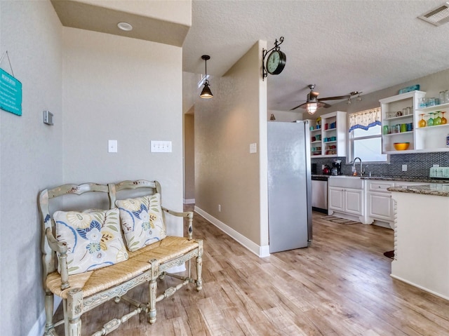 kitchen with pendant lighting, ceiling fan, tasteful backsplash, appliances with stainless steel finishes, and white cabinetry