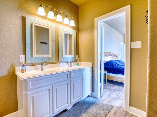 bathroom with dual vanity and wood-type flooring