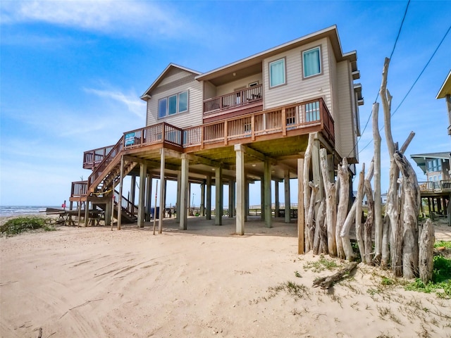 rear view of property featuring a balcony and a deck