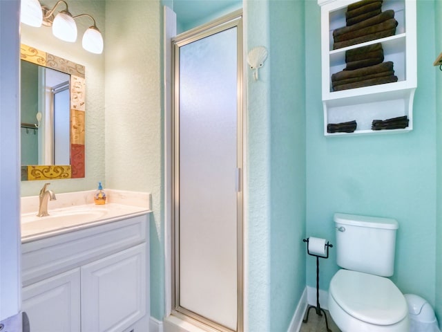 bathroom featuring vanity, a shower with door, and toilet