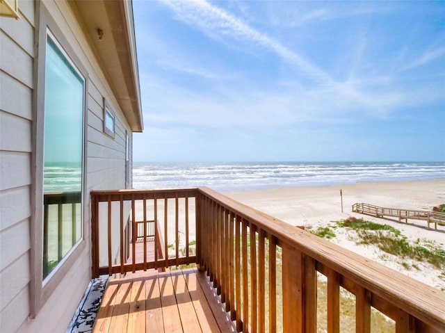 balcony featuring a water view and a view of the beach