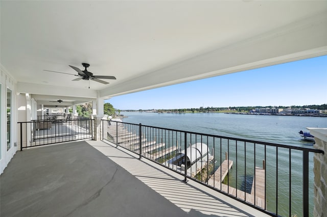 balcony with ceiling fan and a water view