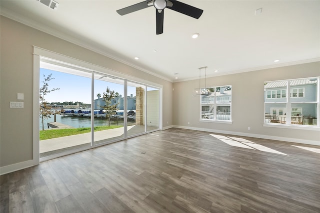 empty room featuring a water view, ceiling fan, dark hardwood / wood-style floors, and a wealth of natural light