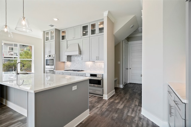 kitchen with decorative light fixtures, dark wood-type flooring, sink, premium range hood, and ornamental molding