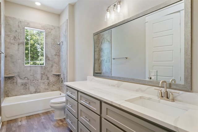 full bathroom with tiled shower / bath, toilet, hardwood / wood-style flooring, and vanity