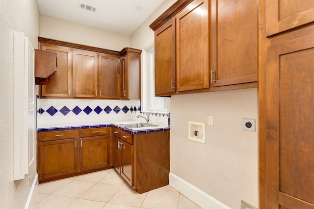 kitchen with light tile flooring, tile countertops, tasteful backsplash, and sink