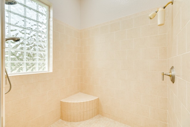 bathroom featuring a wealth of natural light and tiled shower