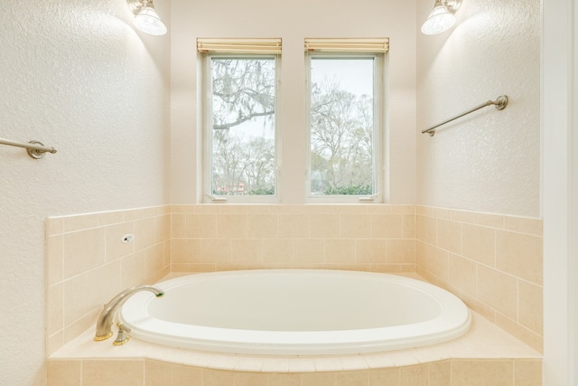 bathroom with a wealth of natural light and tiled bath