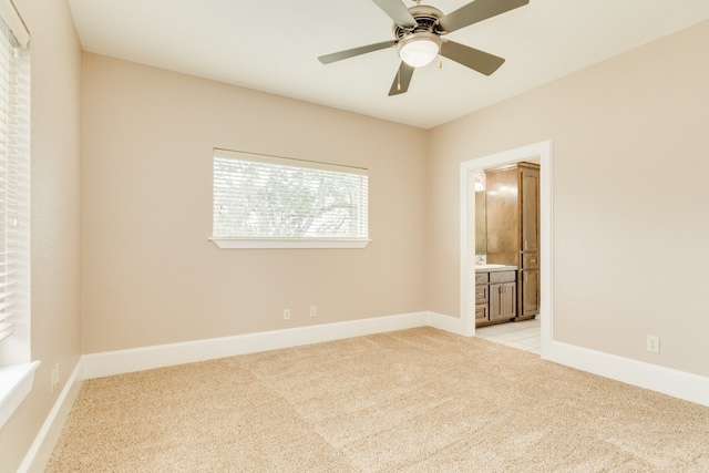 spare room featuring ceiling fan and light carpet