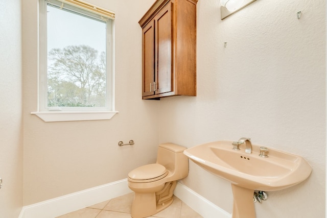 bathroom featuring toilet, tile floors, and sink