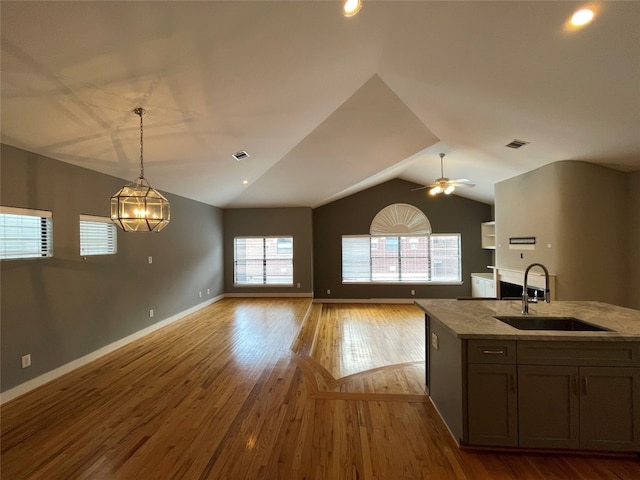 9822 Samantha Suzanne Ct, Houston, TX 77025 - kitchen with pendant lighting, ceiling fan with notable chandelier, light hardwood / wood-style flooring, lofted ceiling, and sink