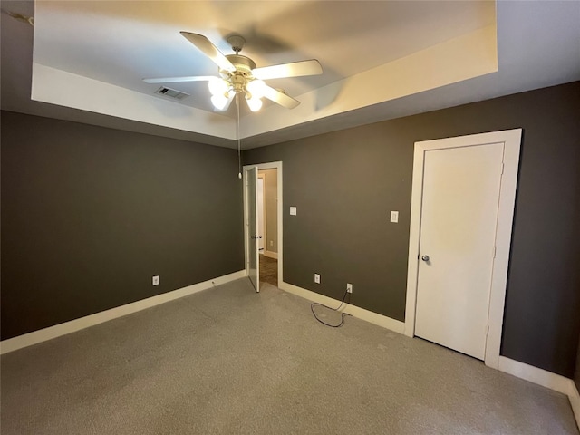 9822 Samantha Suzanne Ct, Houston, TX 77025 - unfurnished room featuring a raised ceiling, ceiling fan, and dark colored carpet