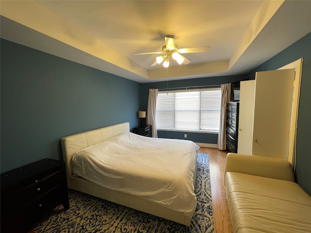 9822 Samantha Suzanne Ct, Houston, TX 77025 - bedroom featuring ceiling fan, dark hardwood / wood-style floors, and a raised ceiling