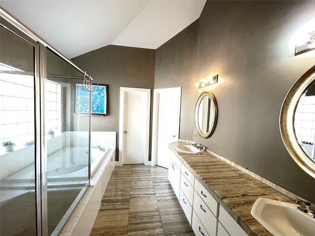 9822 Samantha Suzanne Ct, Houston, TX 77025 - bathroom featuring dual sinks, tile flooring, tiled bath, large vanity, and vaulted ceiling