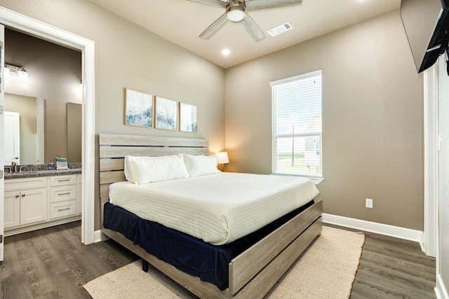 bedroom with ceiling fan, dark hardwood / wood-style floors, sink, and connected bathroom