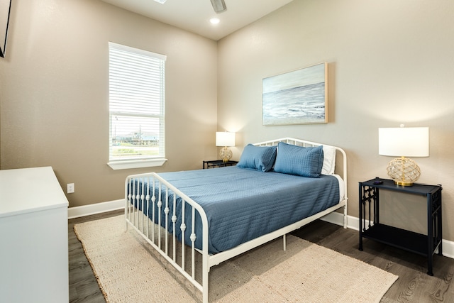 bedroom with dark hardwood / wood-style floors and ceiling fan