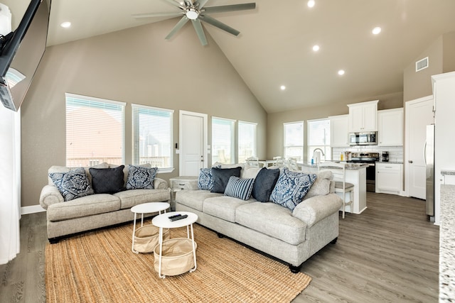 living room featuring high vaulted ceiling, ceiling fan, and light hardwood / wood-style flooring