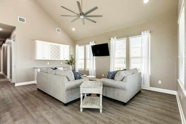 living room featuring dark wood-type flooring, high vaulted ceiling, and ceiling fan