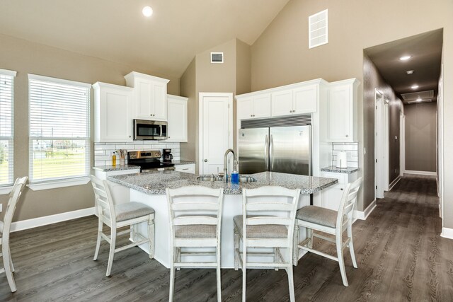 kitchen featuring sink, appliances with stainless steel finishes, backsplash, white cabinets, and dark hardwood / wood-style flooring