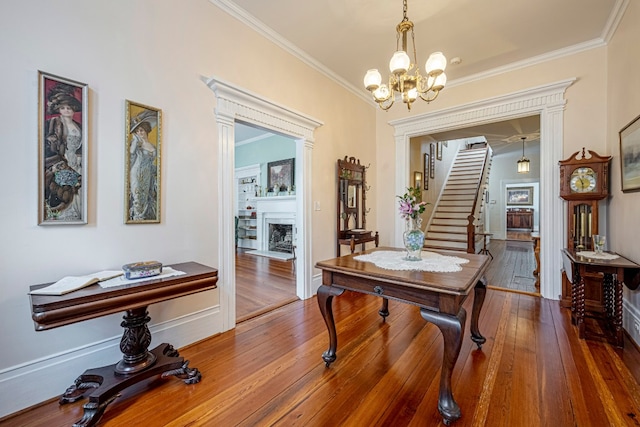 dining room with crown molding, dark wood-type flooring, and an inviting chandelier