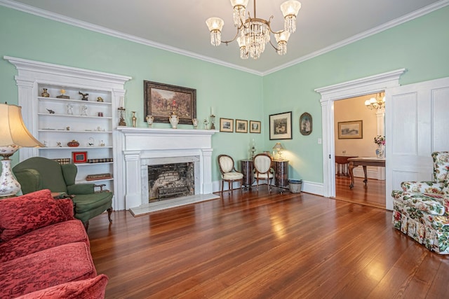 living room featuring a notable chandelier, dark wood-type flooring, ornamental molding, and built in shelves